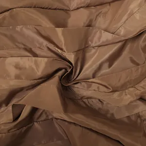 Detailed macro shot of brown shiny pleated fabric texture for women wide leg trousers