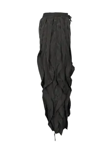 Side view detail of black wide-leg trousers showing layered ruffle and pleated design.