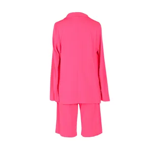 Vista trasera de un traje de dos piezas para mujer en rosa neón con chaqueta y pantalón corto