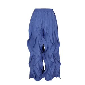 Detail view of blue ruffled wide-leg trousers showing pleated texture and unique design.