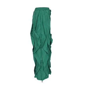 Detailed side view of women's green wide-leg trousers featuring layered ruffled pleats