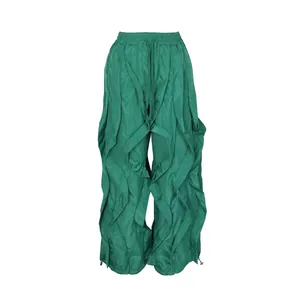 Front view of green ruffled wide-leg pants with pleated layers and drawstring waist.