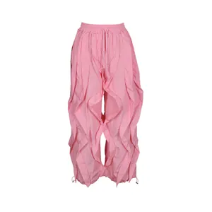 Close-up of pink ruffled wide-leg pants showing the intricate pleated design and texture.