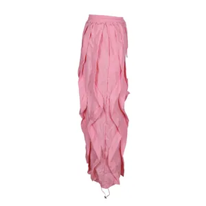 Side profile detail of pink wide-leg trousers featuring vertical ruffles and elastic waist