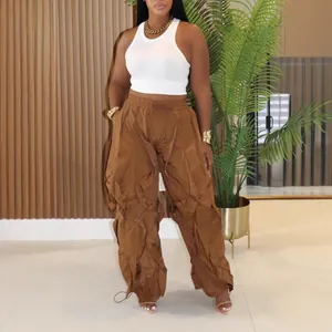 Modern women's casual brown pleated wide-leg trousers paired with a white crop tank top