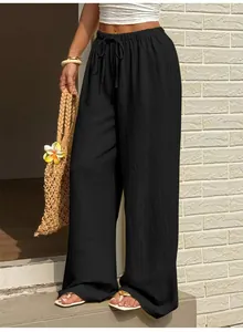 Détail du pantalon noir à jambes larges avec taille haute et cordon de serrage réglable