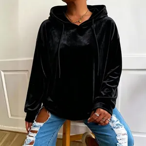 Primer plano de una sudadera con capucha de terciopelo negro, textura suave y holgada