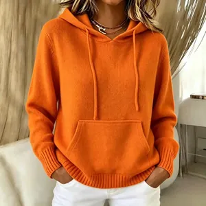 Nahaufnahme eines leuchtend orangefarbenen Strickkapuzenpullovers mit Kängurutasche.