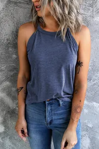Close-up of a women's slate blue halter neck tank top worn by a model with arm tattoos