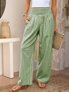 Détail du pantalon large à carreaux verts avec une taille haute élastiquée et smockée
