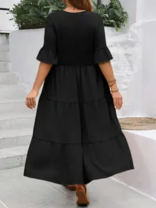 Rückansicht eines schwarzen gestuften Midikleids mit Flatterärmeln im Resort-Stil