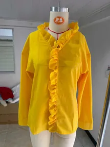 Detailed view of the yellow cotton linen blouse featuring elegant wood ear ruffle trim