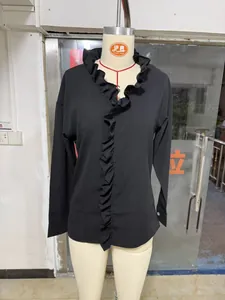 Detailed view of black cotton linen blouse with ruffled collar and cascading front frills