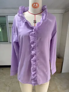 Detailed view of a lavender long-sleeved shirt with elegant ruffle trim on a mannequin