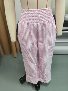 Detail view of women's pink and white striped trousers with high elastic smocked waist