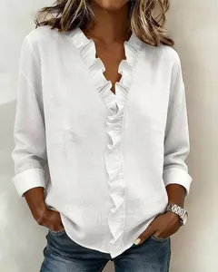 Close-up of white cotton linen top featuring elegant wood-ear ruffled V-neck details.