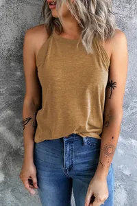 Close-up of mustard yellow halter neck tank top on a model with tattoos