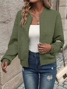 Dettaglio del bomber verde oliva con motivo geometrico a rombi testurizzato.