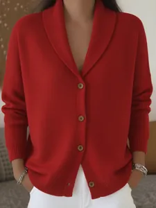 Primer plano de un cárdigan de punto rojo suave con cuello chal y cierre de botones.