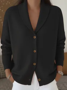Detalle de un elegante cárdigan de punto negro con cuello esmoquin y botones marrones