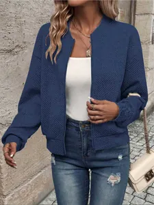 Vista dettagliata della giacca bomber blu con motivo geometrico a rombi.