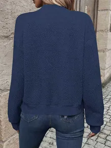 Vista posteriore dettagliata di un top a maniche lunghe blu navy con trama geometrica