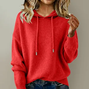 Close-up of a vibrant red knitted hoodie with adjustable drawstrings and soft texture.