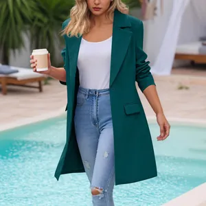 Elegant dark teal mid-length lapel blazer styled with denim jeans in an outdoor pool setting