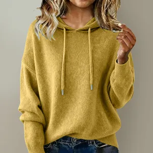 Close-up of yellow knitted texture on a loose drawstring hooded pullover sweater