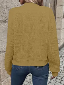 Vista posteriore di una maglia testurizzata a maniche lunghe giallo senape con dettagli.