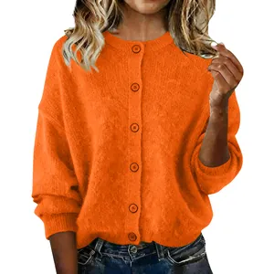 Detail of the orange knit cardigan showing button closures and textured fabric.
