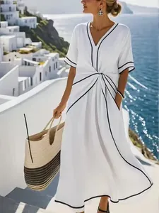 Elegant white V-neck maxi dress with black trim in a Mediterranean coastal resort style