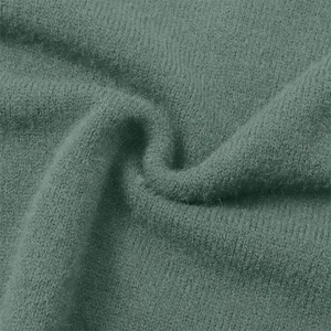 Close-up detail of soft green knitted fabric texture for retro women's fashion sweater