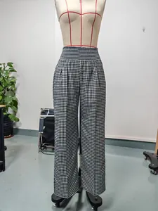Detail of high-waisted black and white checkered wide-leg trousers on a mannequin.