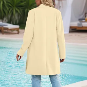 Back view of elegant women's beige mid-length blazer coat in a poolside setting