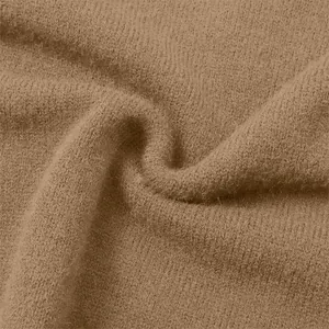 Close-up of soft camel-colored knit fabric showing intricate texture and weave detail.