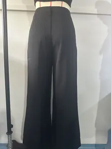 High-waisted black wide-leg trousers detail showing smooth suit fabric and elegant fit