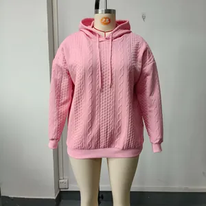 Vista detallada de una sudadera con capucha rosa de punto trenzado en un maniquí