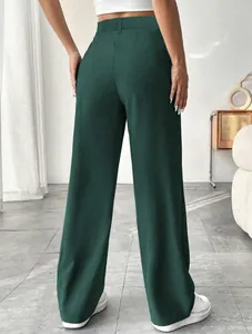 Back view of elegant dark green high-waisted straight-leg dress pants for women