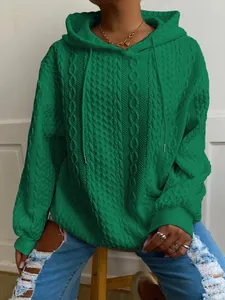 Detalle de una sudadera con capucha verde para mujer con diseño de punto trenzado