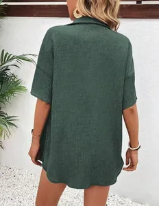 Back view of dark green loose casual linen textured shirt showing fabric detail.