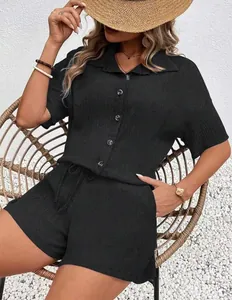 Detailed view of women's black short-sleeve button-up set on wicker chair
