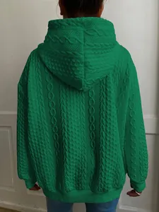 Detalle de la espalda de una sudadera verde esmeralda con capucha y punto de trenza