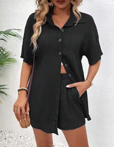 Detail view showing the texture of black cotton gauze shirt and shorts set on a fashion model.