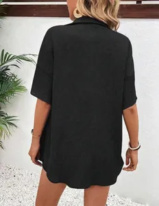 Back view of an elegant loose black short-sleeve top featuring textured fabric.