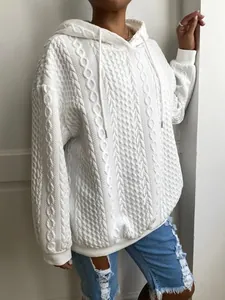 Detalle de la textura de punto de ochos de una sudadera blanca con capucha para mujer