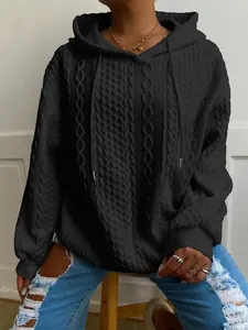 Vista de detalle de sudadera negra con capucha y patrones de punto de ocho texturizados