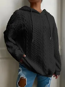 Vista detallada de sudadera negra con capucha y textura de punto de ochos jacquard