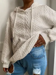 Detalle de primer plano que muestra la textura de punto de ochos blanco de esta sudadera con capucha
