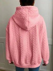 Vista posterior detallada de una sudadera rosa con capucha y textura de trenzas